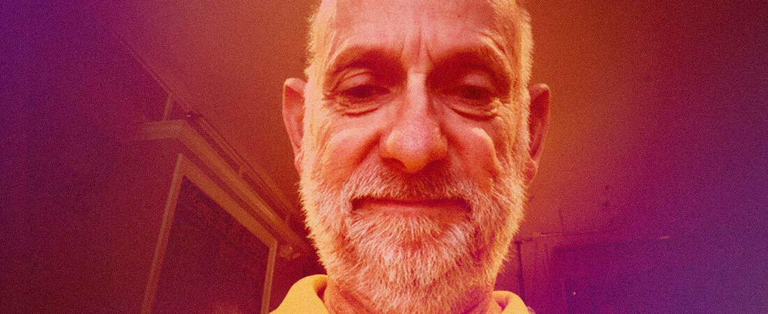 An image of David Pais with an orange/red light filter
